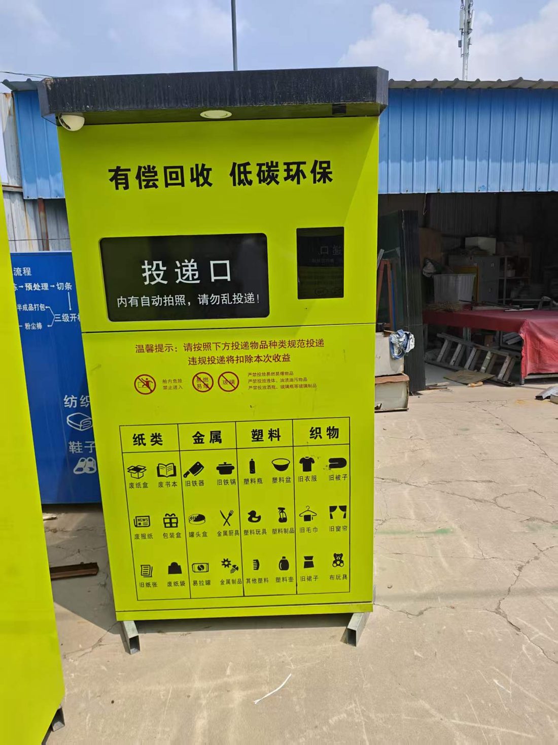 智能回收箱投放口细节实拍，内有自动拍照提示与禁止投递物品说明、四分类图例